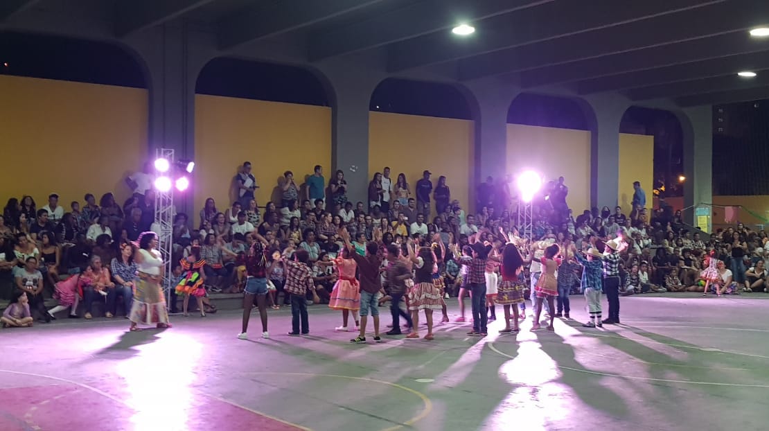 Estudantes performando uma coreografia na festa junina